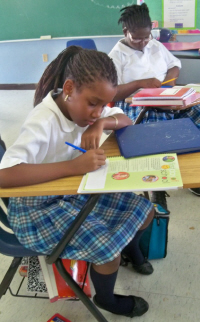 Chellsee JnFrancois (left) and Mone't Martin put their names in their Coole School planners. 