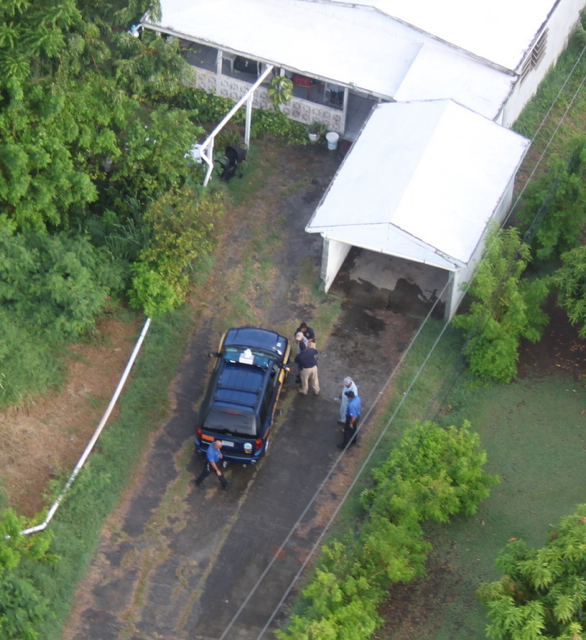 Photo from helicopter shows police arresting domestic violence suspect in tan hat.