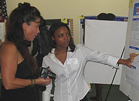 UVI Junior Marisha Perkins (right) explains her methylation project to a visitor.