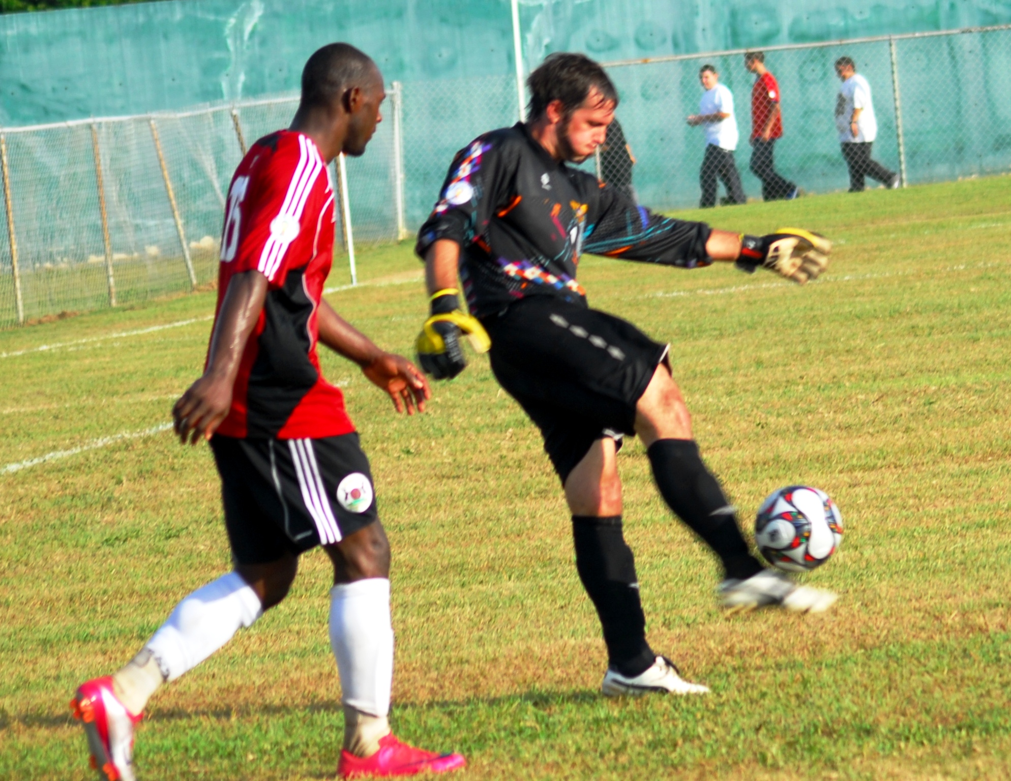 V.I. goalkeeper Dillon Pieffer (right) being shadowed by Antigua and Barbuda’s Peter Byers.
