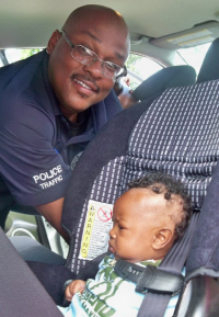 Officer Arthur Joseph puts Amari Patrick in his seat. 