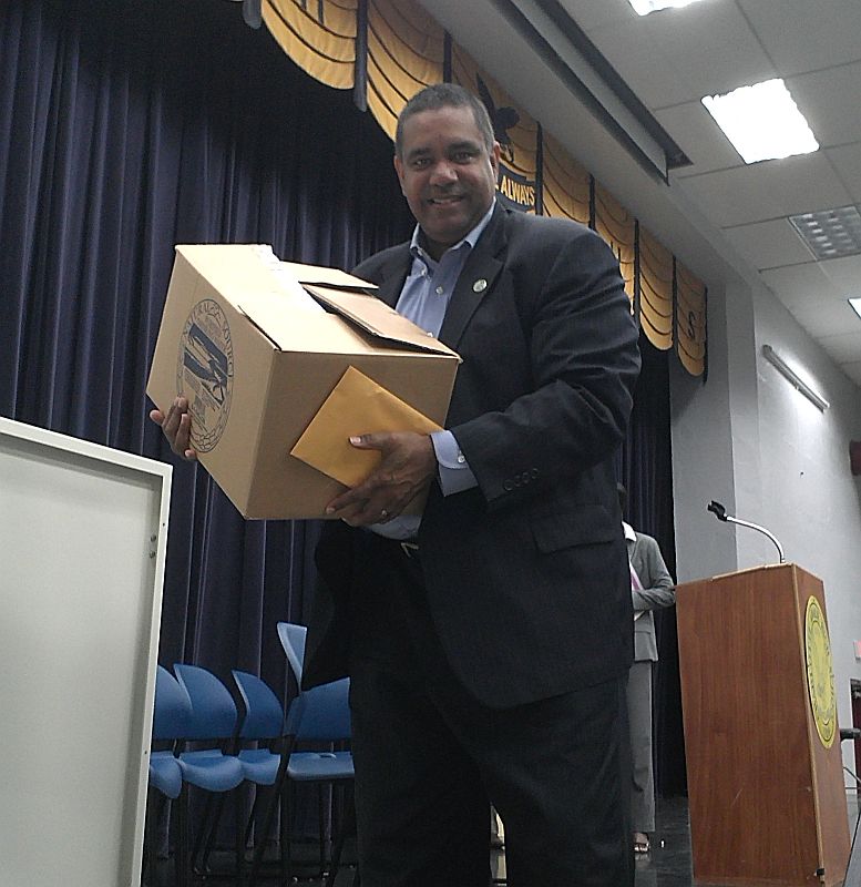 Gov. John deJongh Jr. helps students load boxes containing donated food, clothing and toiletries into Catholic Charities vehicles.