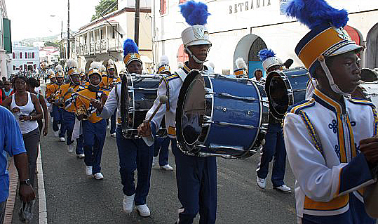 Charlotte Amalie High School's flag team and Marching Hawks band parade down Main Street.