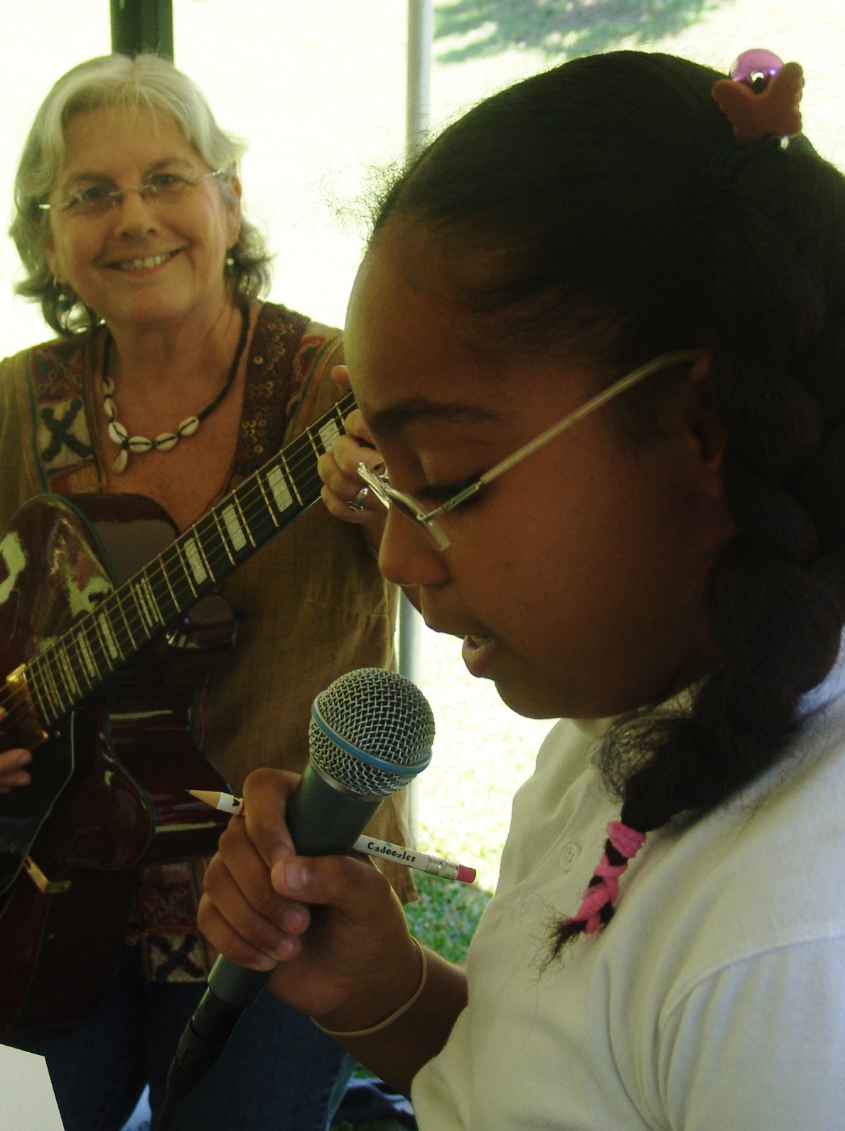 Kimberly Cordero, 12, of Lew Muckle Elementary, sings on Earth Day with Jan Hart accompanying on guitar.
