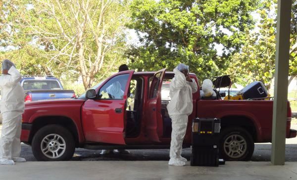 Contractors suit up to clean fire extinguisher residue left by vandals.