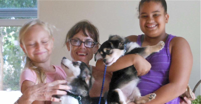 Gabrielle Higgs, left, and Danielle Parker help Beth Downey with her new pups.