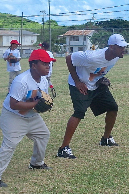 Kemoi George, a 9-year-old member of the St. Croix Dodgers, lines up with major leaguer Jabari Blash.