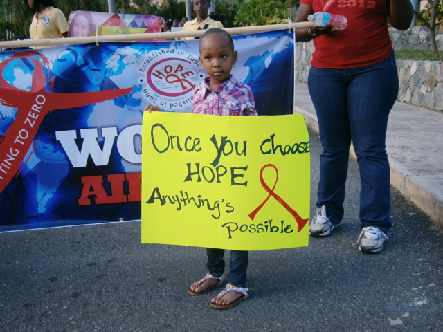 A&rsquo;tijah Colaire, 4, carries a poster in Saturday's AIDS Awareness Day Parade.