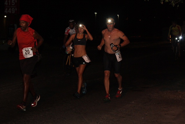 Lit by headlamps, marathoners hit the streets before dawn.