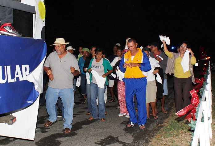 Revelers march behind the band during the Crucian Christmas Serenade.