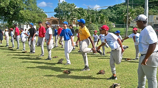 Local Little Leaguers and big league players stretch at the start of the clinic.