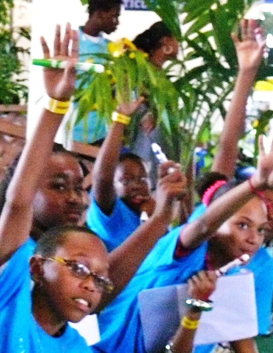 4-H-ers eagerly raise their hands to help contestants answer questions during a mock TV game show.