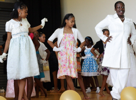 Sherrayn Garcia (right) gives modeling tips to elementary girls at the Little Princess Tea Party Leadership Seminar.