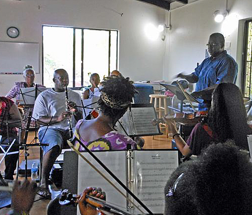 James Gumbs (right) leads the orchestra in rehearsal.