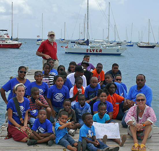 Some two dozen Boys and Girls Club kids join O'Neil Canton (far right) and Anne Wachtmeister (in front of Canton) in thanking John "Big Beard" Macy (standing) for donating his sailing catamaran The Flyer. (click to enlarge)