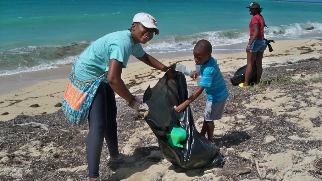 Jether William, left, and her five-year-old son, Gabriel, pick up trash at Sandy Point Refuge. 