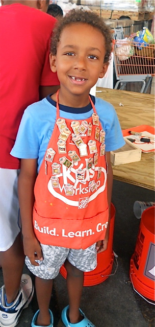 Kobe Rhymer shows off the many pins he has earned at the Home Depot children's workshops.