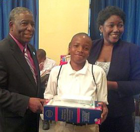 Lt. Gov Gregory R. Francis (left) and Education Commissioner LaVerne Terry present Bass with the hefty Webster's International Dictionary.