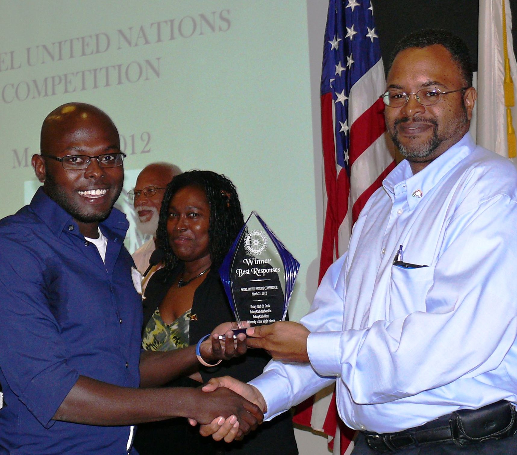 UVI senior Maxence Jeanty accepts the prize for best responses from Rotarian David Beck.