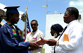 Bureau of Corrections Director Julius Wilson (right) congratulates a Golden Grove inmate on earning his GED.