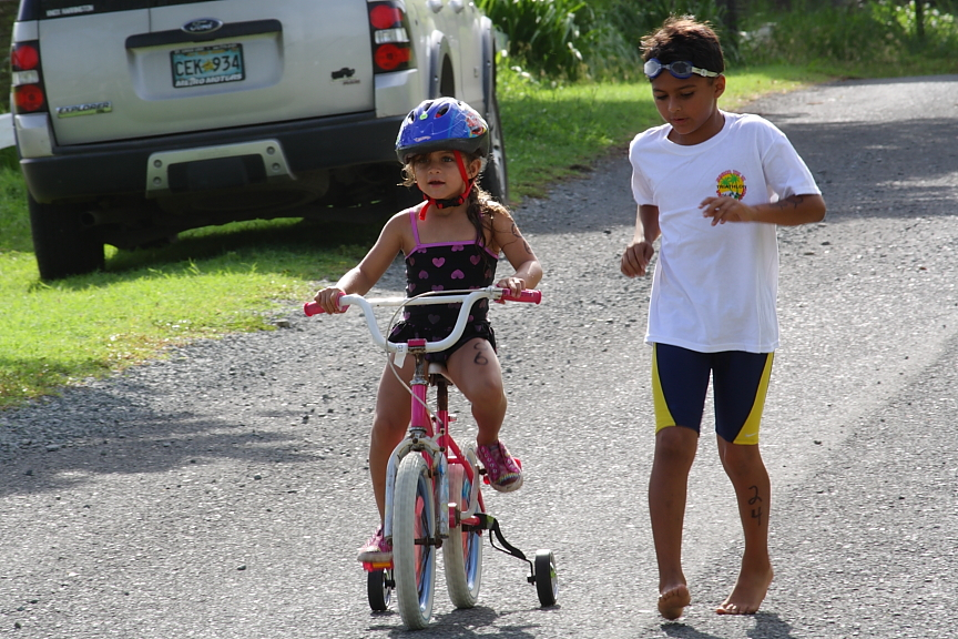 Michael Adams runs along his sister Angelisa as she competes in the 5-6-year-old race.