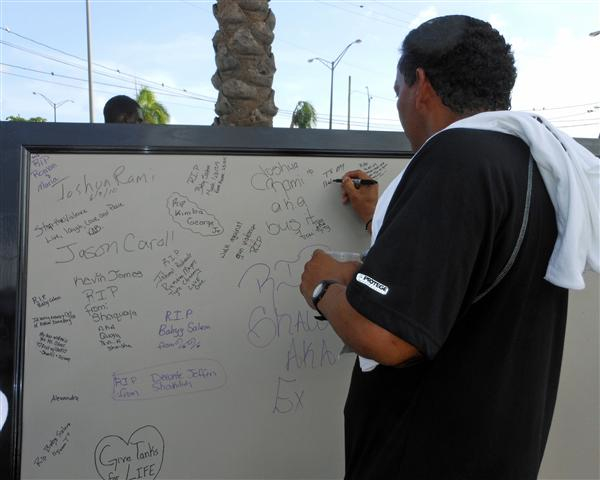 A runner leaves a message on the memorial board Sunday.