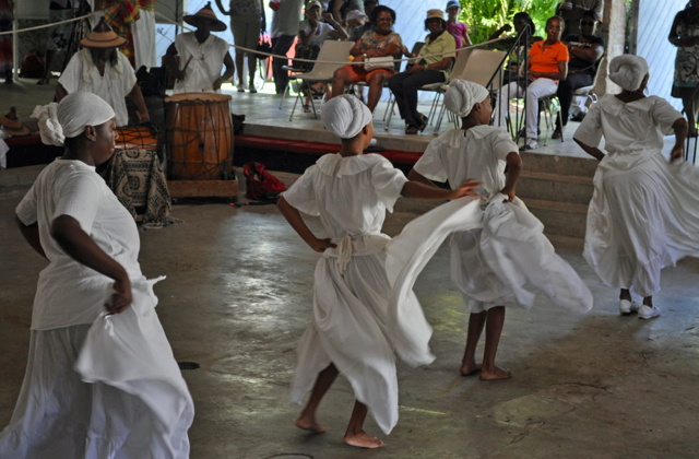Members of the Per Ankh Dance Troupe perform a bamboula dance as drummers beat a rhythm in the background.
