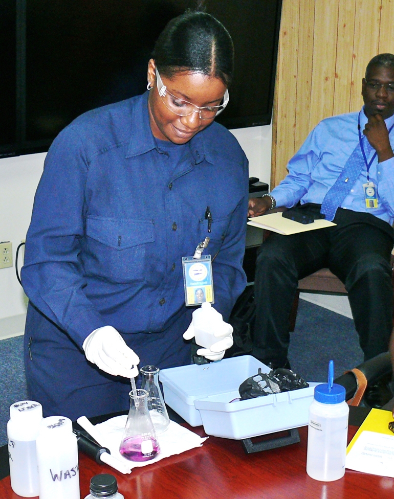 Lab technician Nailah Elliott shows the WAPA governing board one of the tests she performs on boiler water at its St. Croix plant (Bill Kossler photo).