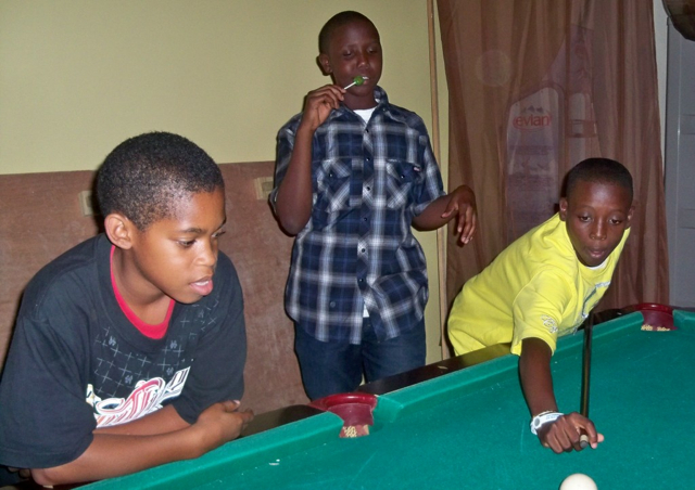 From left, 11-year-old Heneas McLeod, 13-year-old Micah Tyson and Marquise Seres, 12, shoot pool at Friday Night Live. 