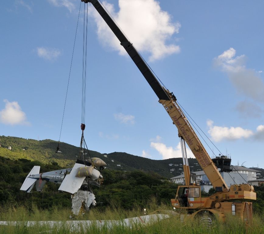 Plane being lifted by crane from the waters adjacent to Cyril E. King Airport runway on Sunday.