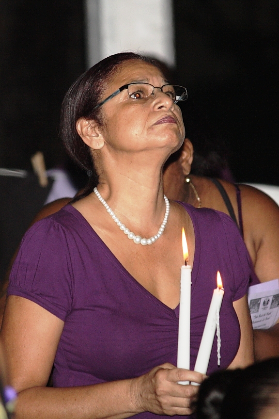 Maria Friday holds a candle in remembrance of her friend, Lorraine Joseph.