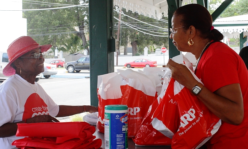 AARP Foundation volunteers Joan Sackey, left, and Cheryl Harley prepare hygiene bags for the homeless.