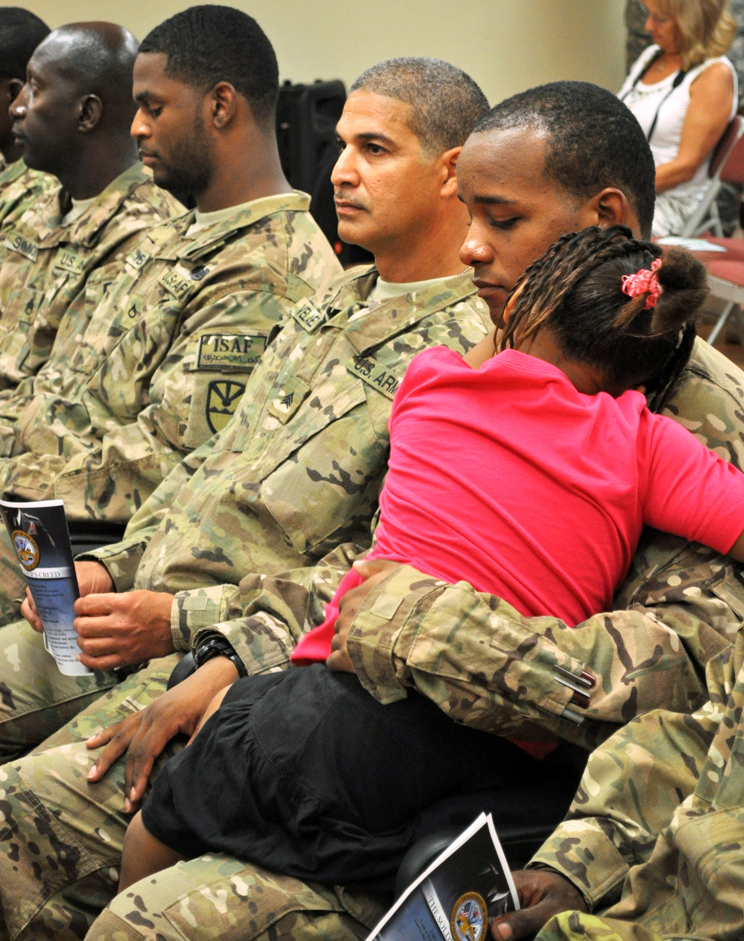 VING 104th RAID troops listening to one of the welcome home event's speakers. The little girl never left this soldier's lap throughout the entire ceremony. 