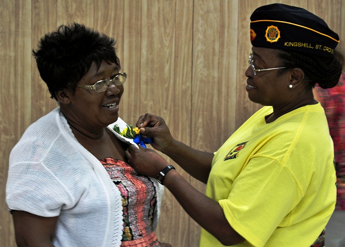 Ophelia Walters, who lost her daughter Claudia Sutton in the 9/11 attacks, is pinned and honored by American Legion Cmdr. Annie Day Henry. 