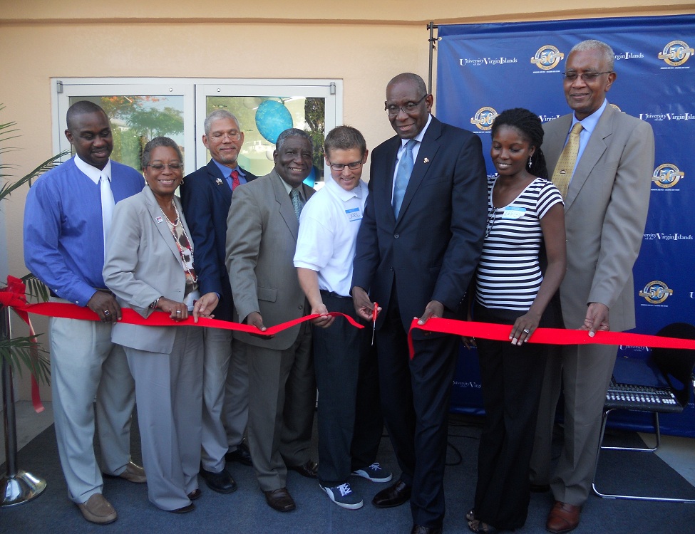 UVI President David Hall cuts the ribbon at the new residence hall with other university representatives and speakers.