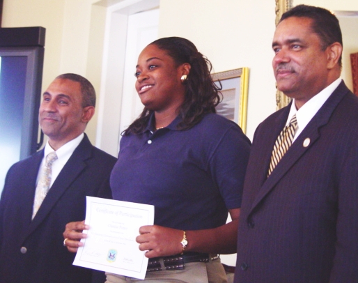 Chanel Potter receives her certificate as a 911 Dispatcher from Gov. John deJongh and VITEMA Director Mark Walters in a ceremony Monday at Government House.