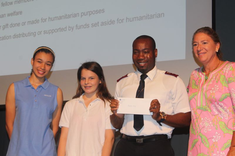 Salvation Army Capt. Kevin Bryan accepts a check from students Anika Hahnfeld and Andy Williams, along with Antilles Head of School Liz Morrison