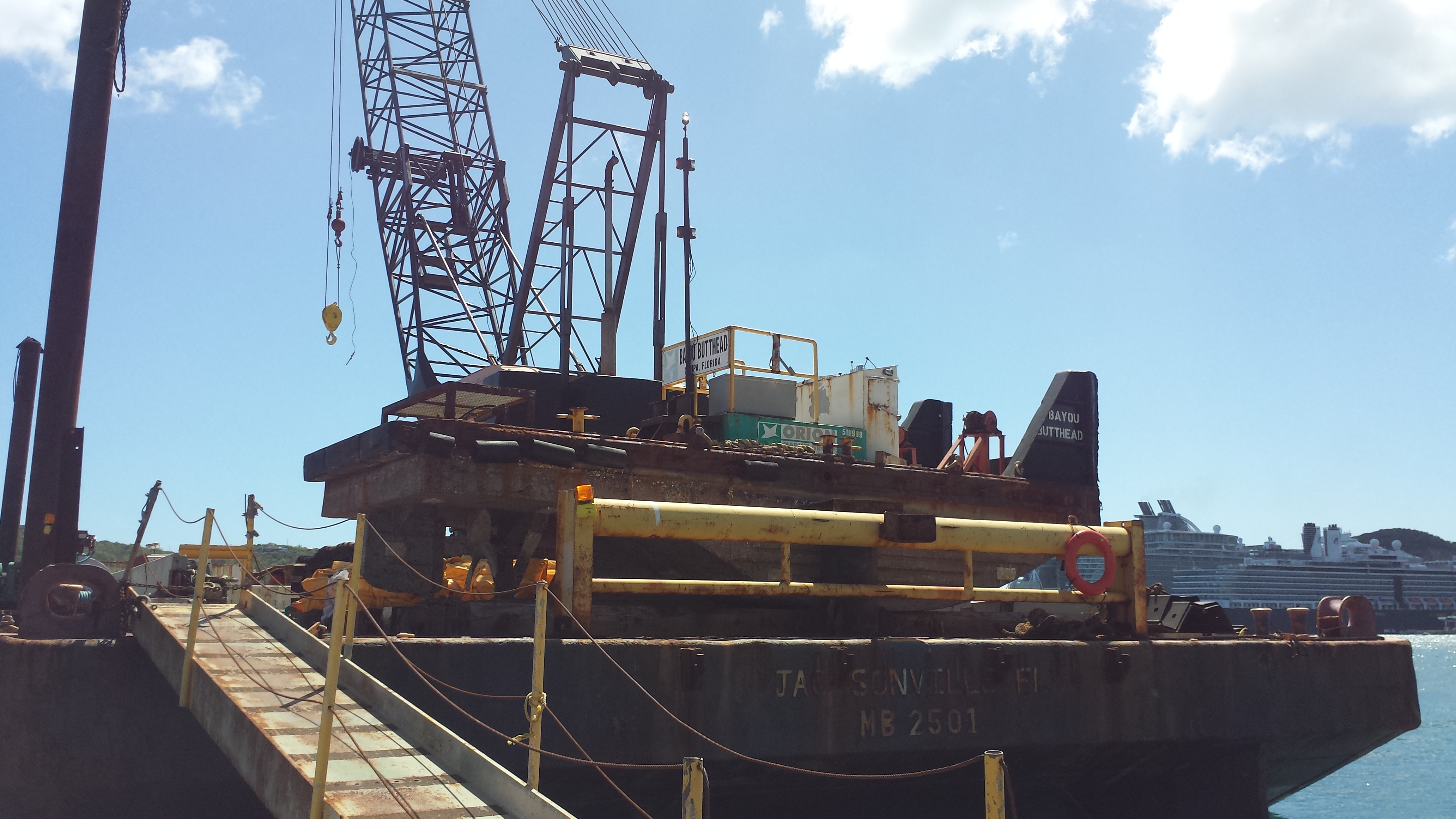 The barge operated by Orion Marine Construction Inc. is stationed in Crown Bay as workers prepare the silt curtain to begin dredging. 