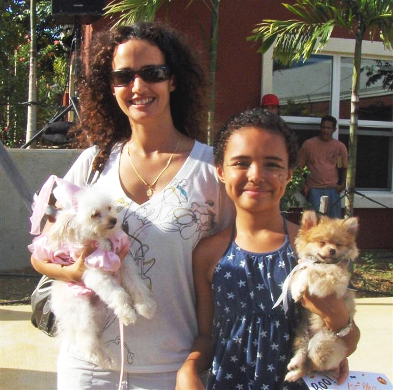Helen (left) and Imani Sidiropoulos hold pomapoos Cookie and Gizmo, who took first place in the costume contest.