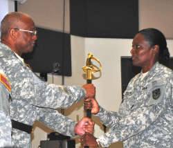 Maj. Gen. Renaldo Rivera (left) passes the sword to State Command Sgt. Maj. Mona L. Barnes.