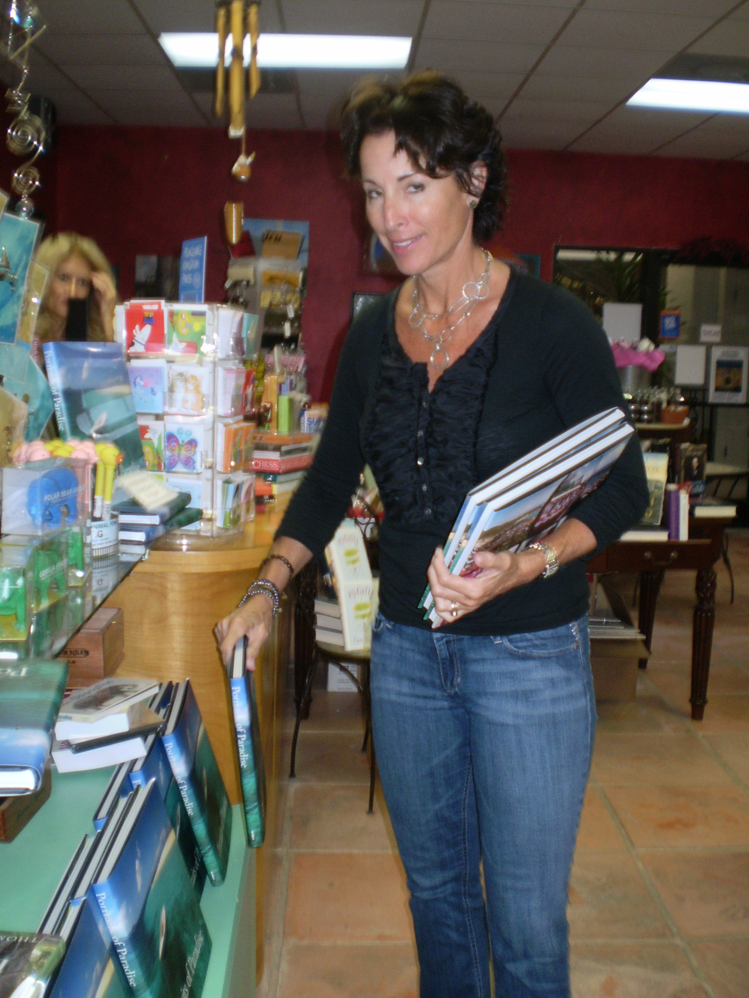 Undercover Books owner Kathy Bennett stocking "Portraits of Paradise."