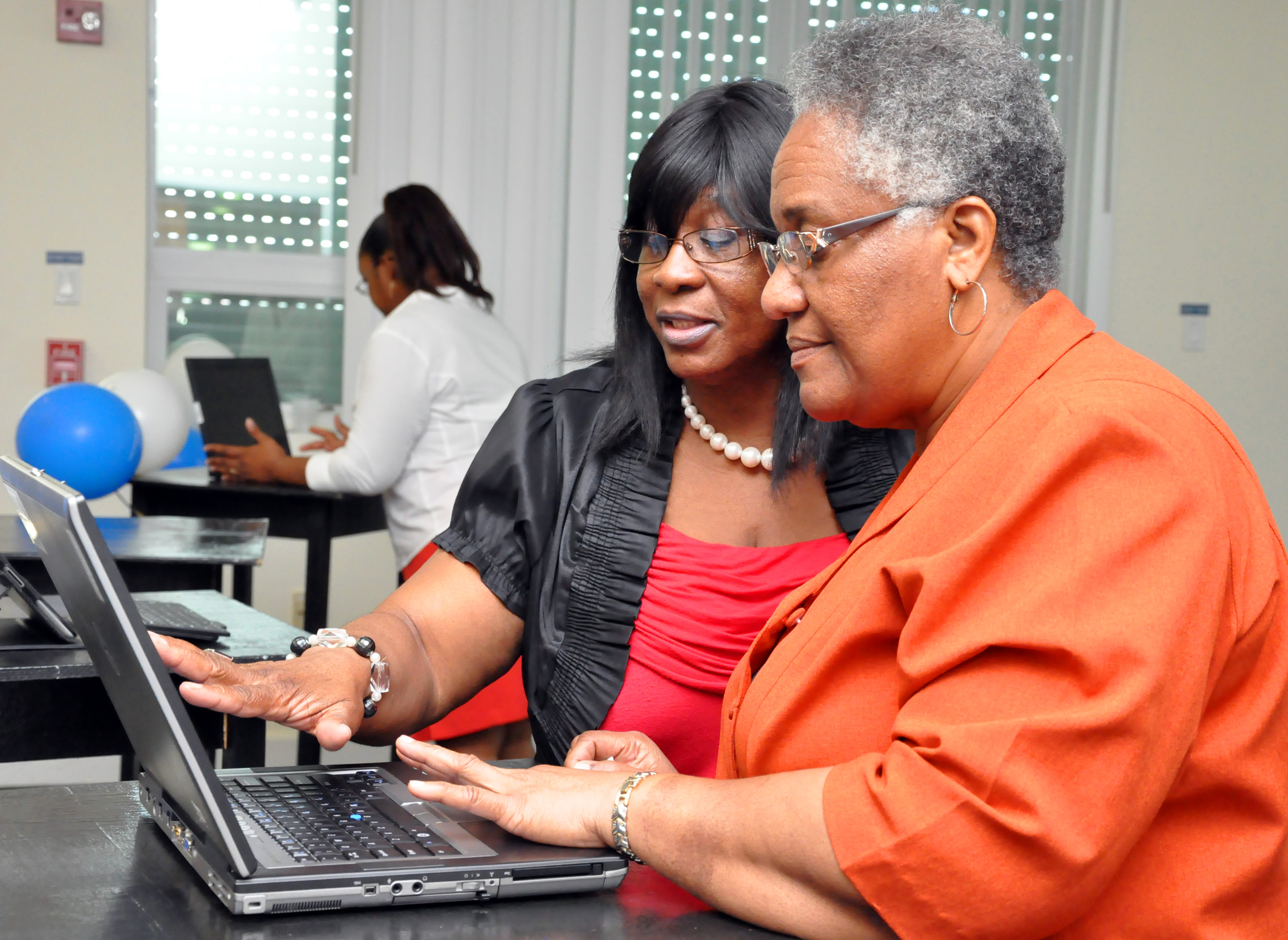 UVI Administrative Assistant Lois Rivera shares the university’s new Web site with her colleague, Marlene Thomas, at UVI’s Web site launch presentation.