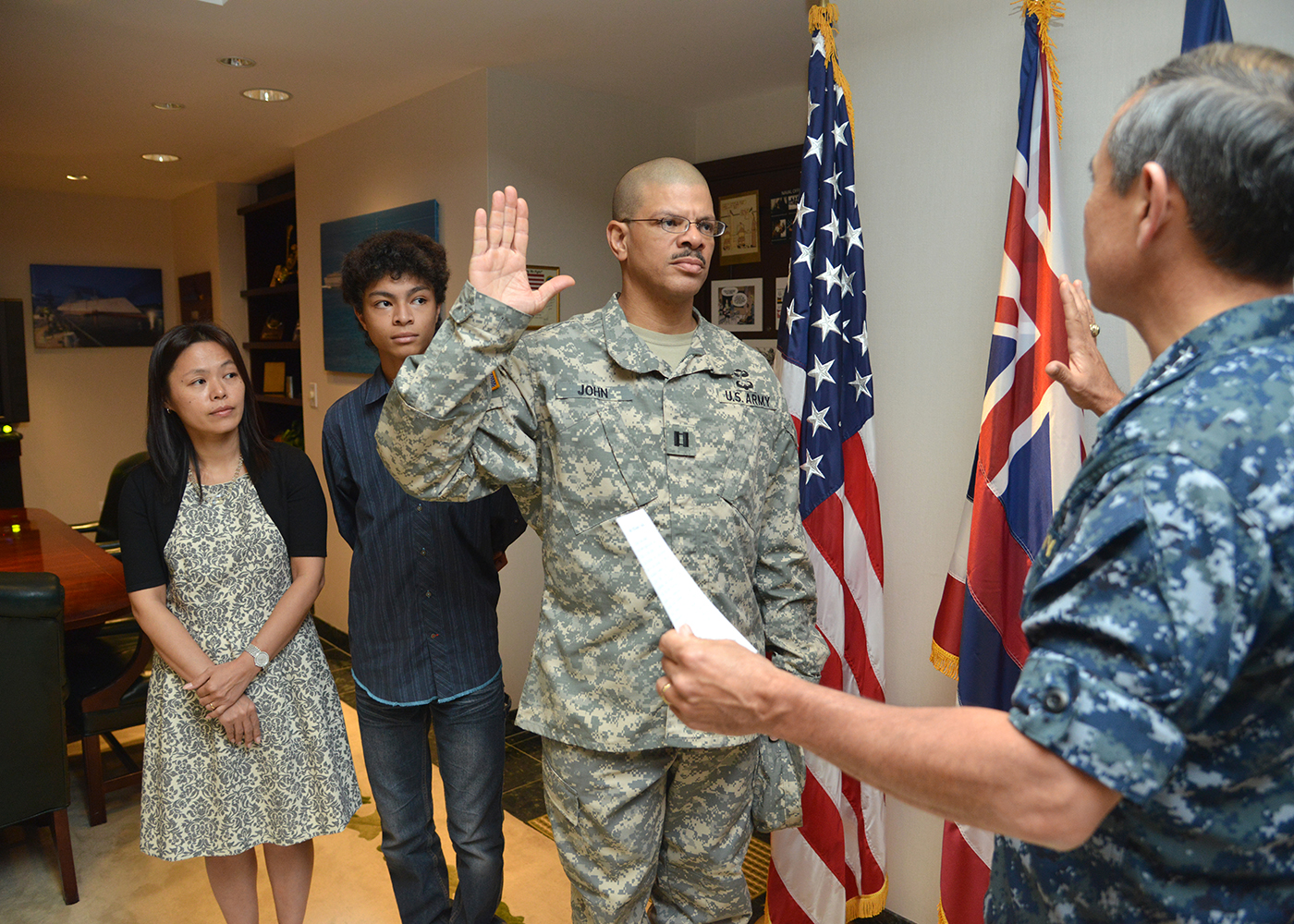 Army Maj. Anthony E. John, Command Safety Officer, USAR TSG-P reaffirms the commissioned officers oath of office right before he was officially pinned to his current rank by Adm. Harry B. Harris Jr., commander, U.S. Pacific Fleet, while his wife, Yuki, and son, Paul, look on during a promotion ceremony held at US PACFLT Headquarters, Pearl Harbor, Hawaii, on Nov. 25, 2013. (Photo provided by MC1 Amanda Dunford, PACFLT PAO)
