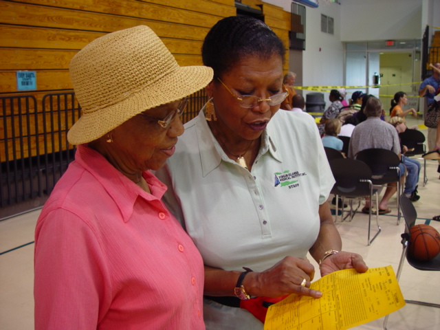Event organizer Dr. Cora Christian (right) reviews Beatrice Gumbs' chart with her. 