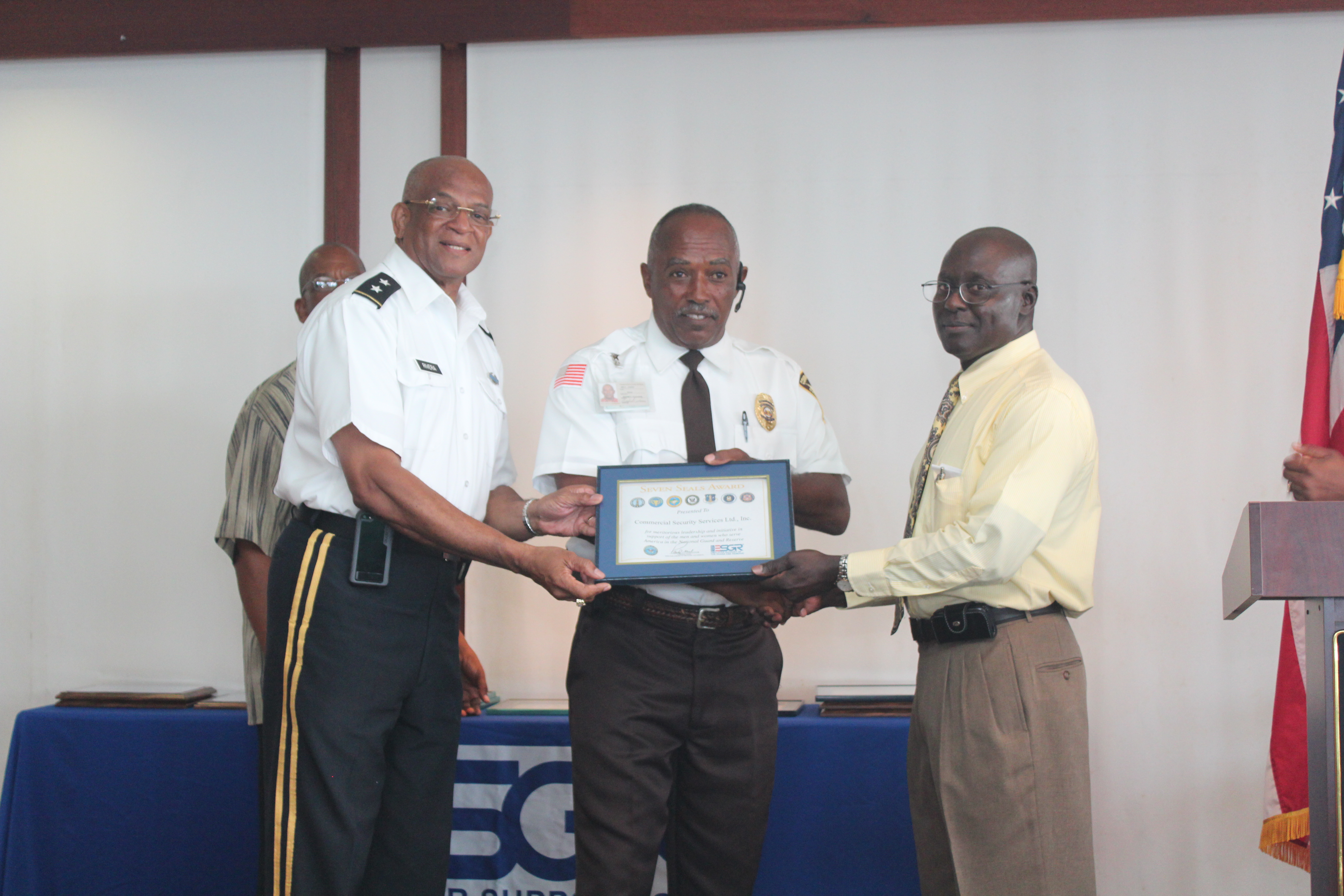 Adjutant General Major General Renaldo Rivera and V.I. State Chair present Commercial Security Services Inc. with a Seven Seals Award. Emil James, director, accepted the award on behalf of the company. James stated, "He hires military personnel because of their appearance and ability to work long hours and at remote locations."