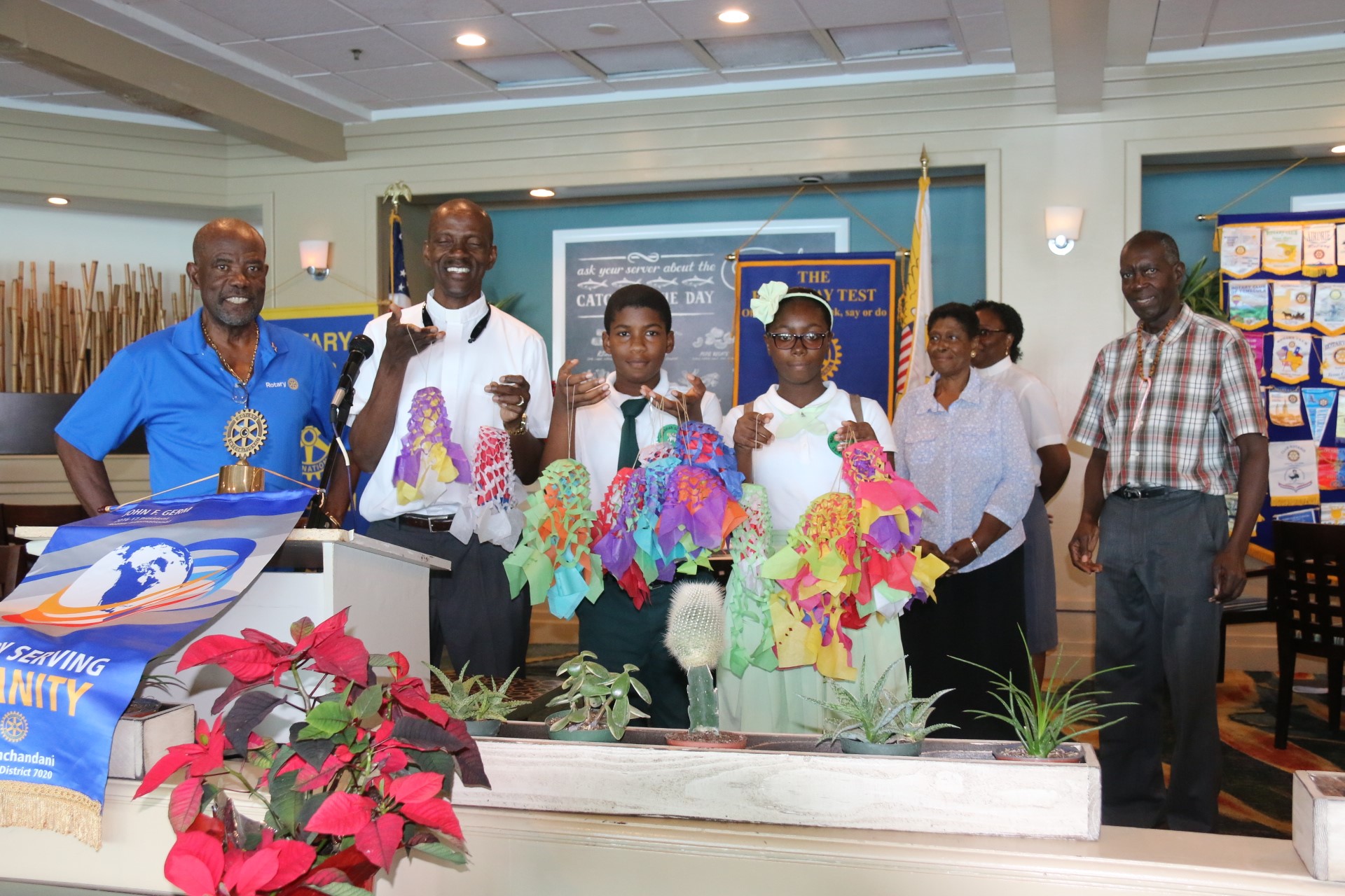 The Moravian School principal, Rev. Dr. Errol Connor, along with 7th grader Latanya McDowell and 6th grader Akim Plaskett present Christmas Bells to Rotary Club St. Thomas II members.