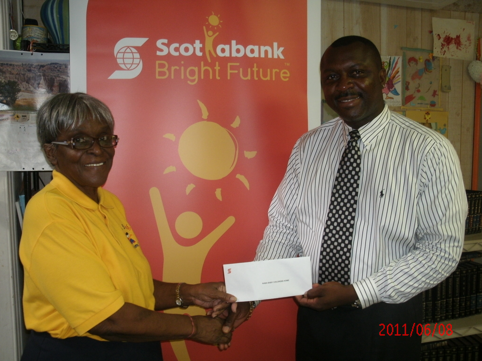 Beulah Wilson, Director of Nana Baby Children’s Home on St. Thomas, accepts a donation from  Scotiabank Branch Manager, Steve Gardner as part of the Scotiabank Bright Future program.