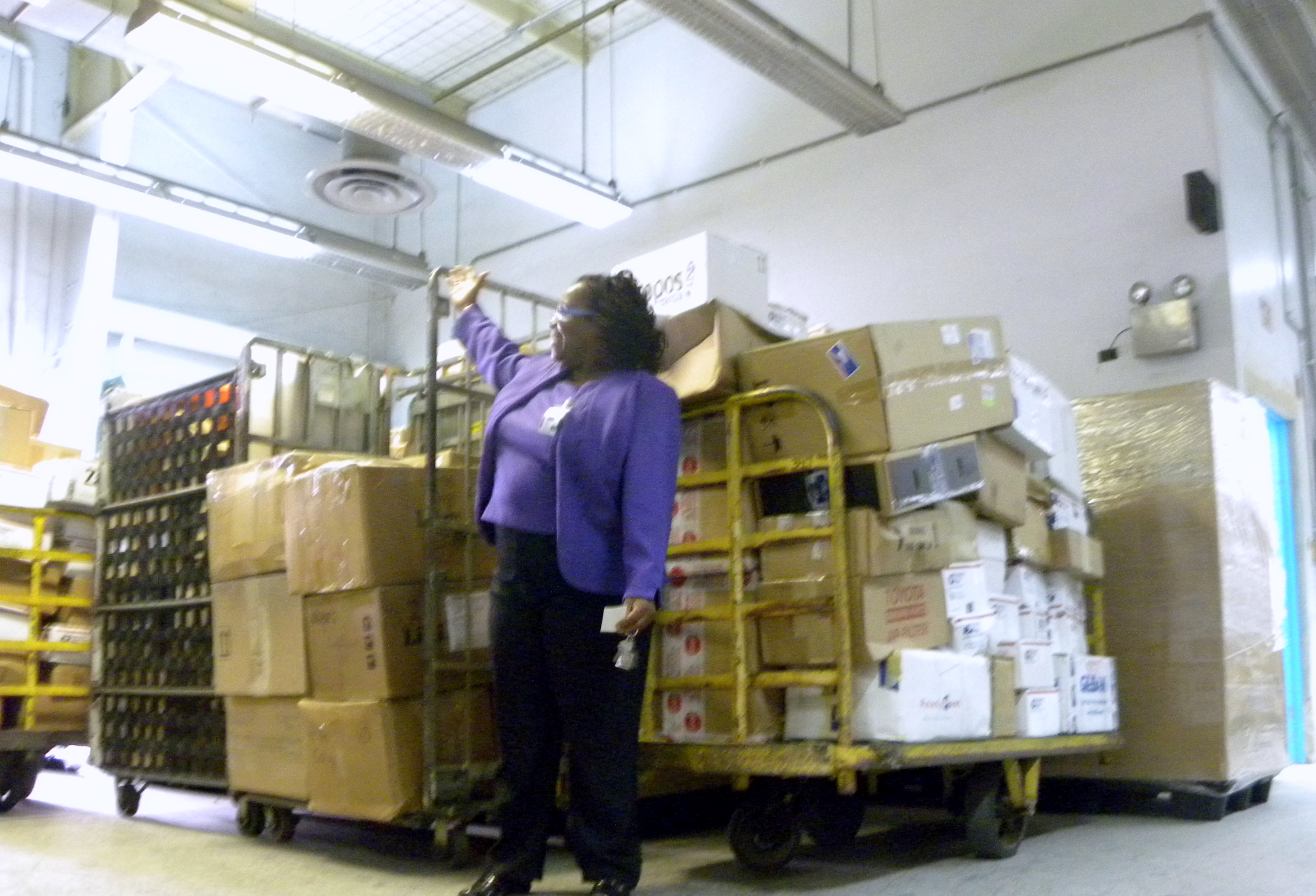 Postmaster Silva T. Gibbs with one of six loads of mail arriving by plane Tuesday.