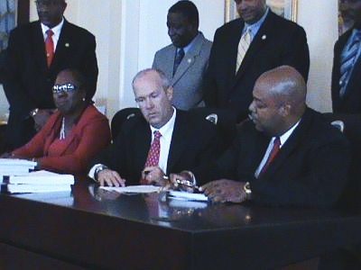 From left: May Adams Cornwall, James Beach and Hugo Hodge Jr. sign agreements with WAPA and WMA during Monday's press conference.