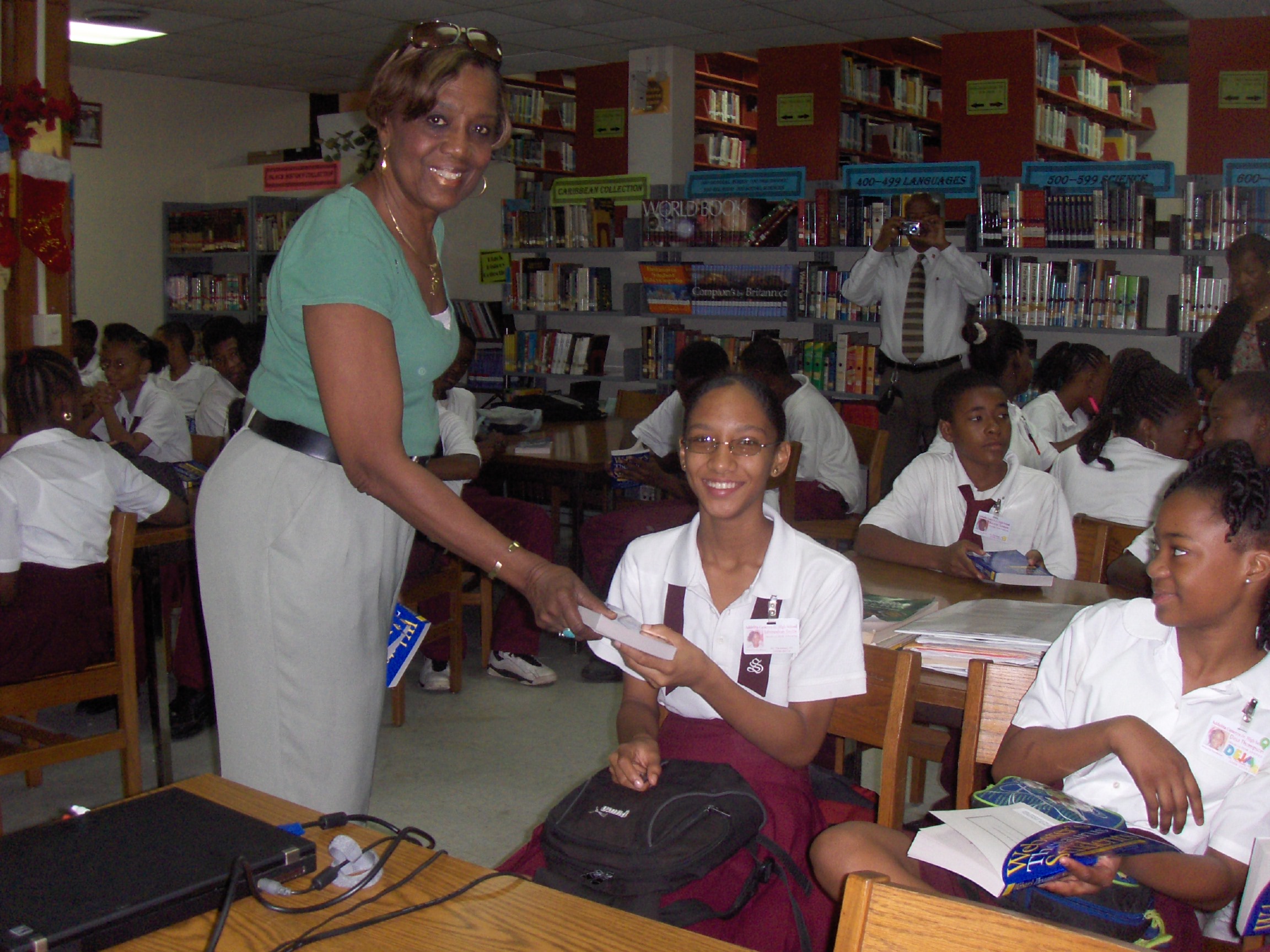 Cancryn teacher Ida White presents a thesaurus to Asysha Smith, while Deja Thompson looks on.